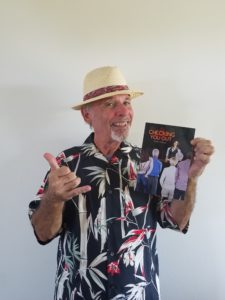 Picture of Dorrance author, John Chaput holding his book, "Checking You Out."