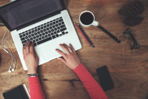 woman typing at coffee shop