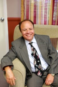 Picture of Dorrance publishing author, Victor Boctor sitting on a tan arm chair.