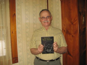Dorrance Publishing author, Alan Clark, holding his book, "Silent Partner."