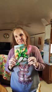 Picture of Linda Crichton holding her book, "Dragons Cowboys and Other Mythical Creatures."